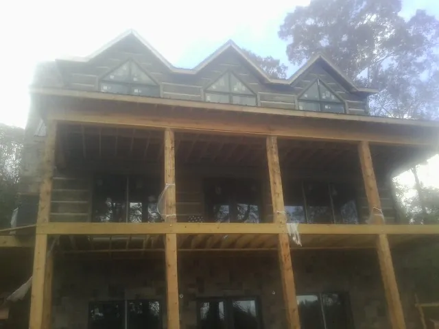 Dormers and porch framing on a large log home under construction in Gum Spring