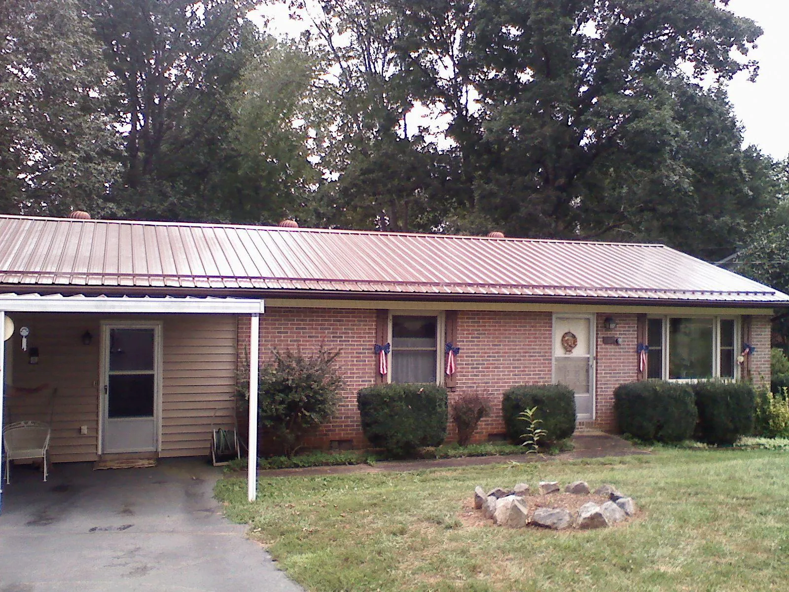 Bronze metal roof and carport on a brick ranch home — Roof Repair work by our crew in Gum Spring